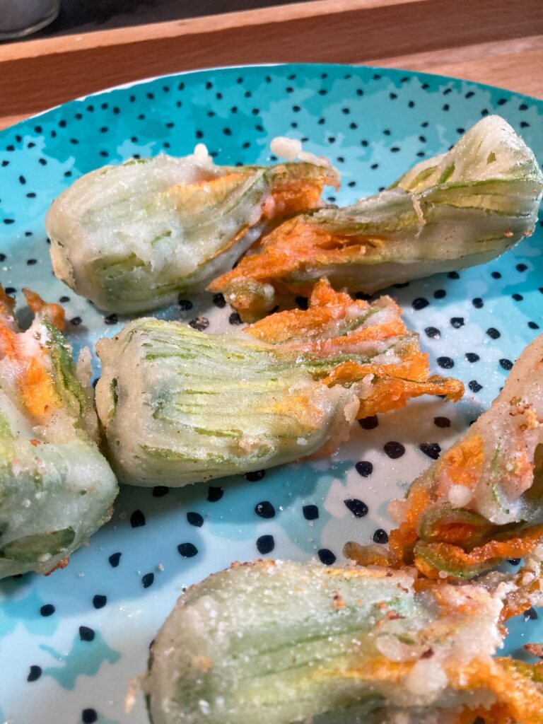 Fiori di zucca fritti in farina di riso ripieni di taleggio e ricotta visti da vicino